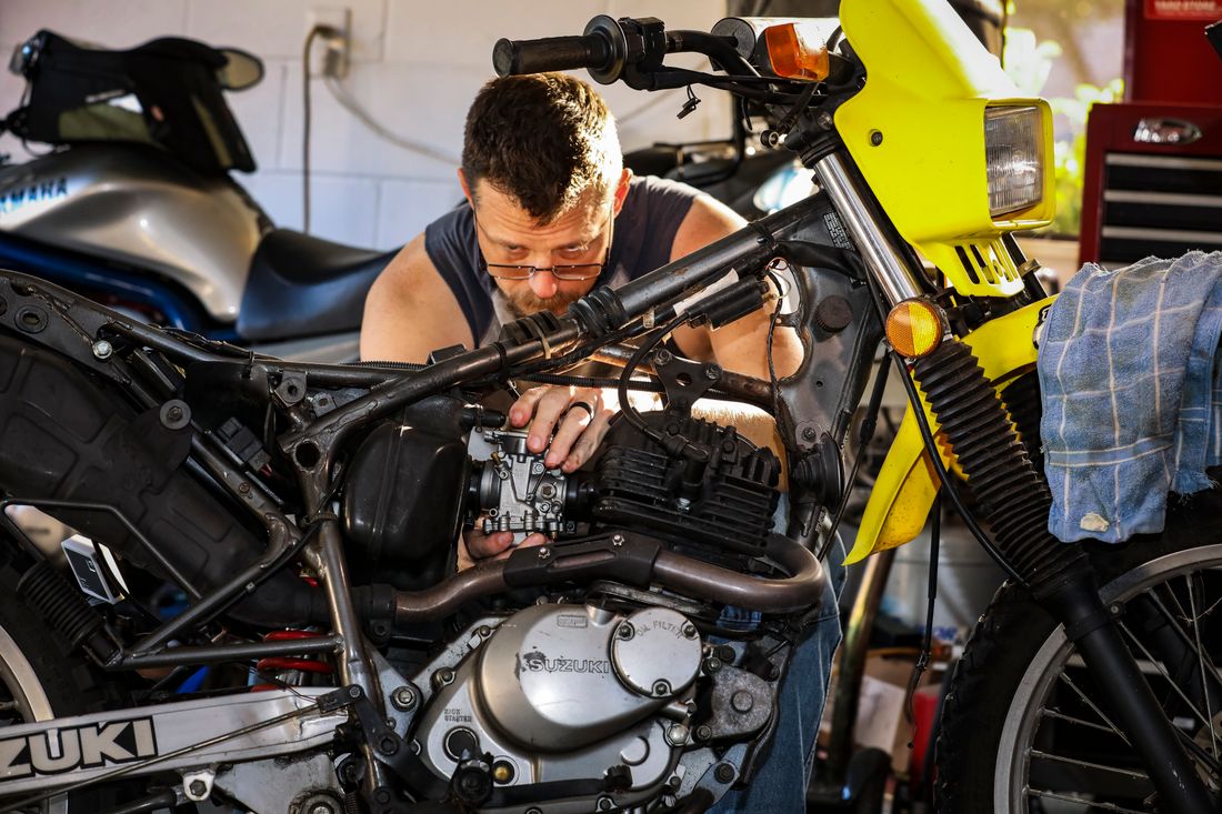 Technician repairing a motorcycle engine in a workshop