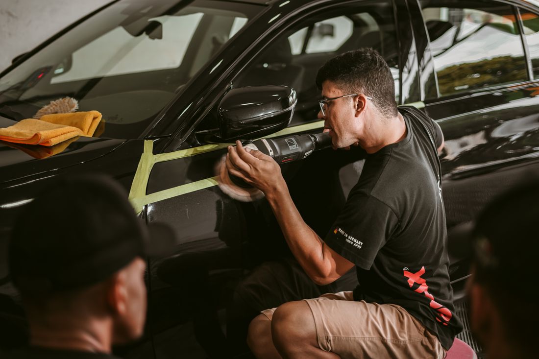 Detailer machine-polishing a vehicle to a deep gloss finish